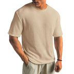 Khaki waffle-knit T-shirt worn with light linen trousers, showing the short sleeve and straight hem