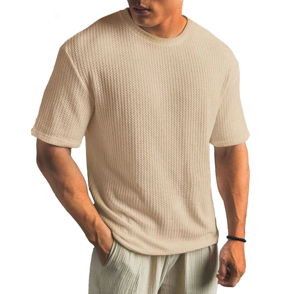 Khaki waffle-knit T-shirt worn with light linen trousers, showing the short sleeve and straight hem