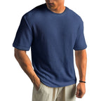 Navy blue waffle-knit T-shirt with short sleeves, showing the fabric texture across the chest