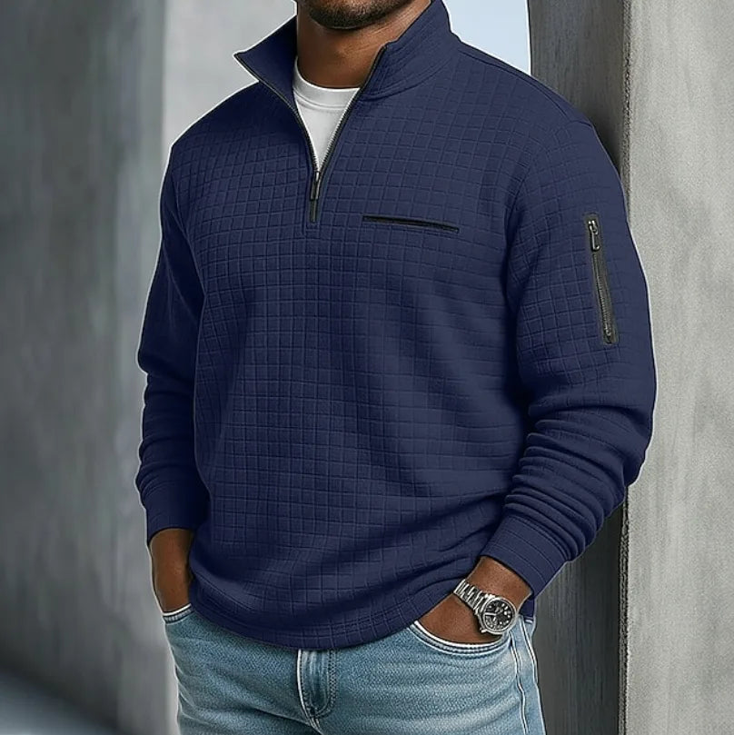 Navy blue quilted waffle-knit quarter-zip pullover shown with the collar standing up and sleeve zip pocket