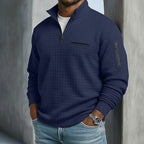 Navy blue quilted waffle-knit quarter-zip pullover shown with the collar standing up and sleeve zip pocket