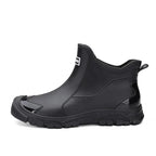 Side profile of a black rubber chelsea boot on a plain white background