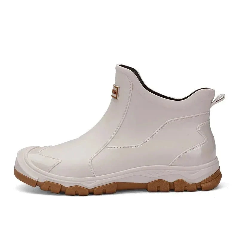 Side profile of a beige rubber chelsea boot showing tan sole on a plain white background