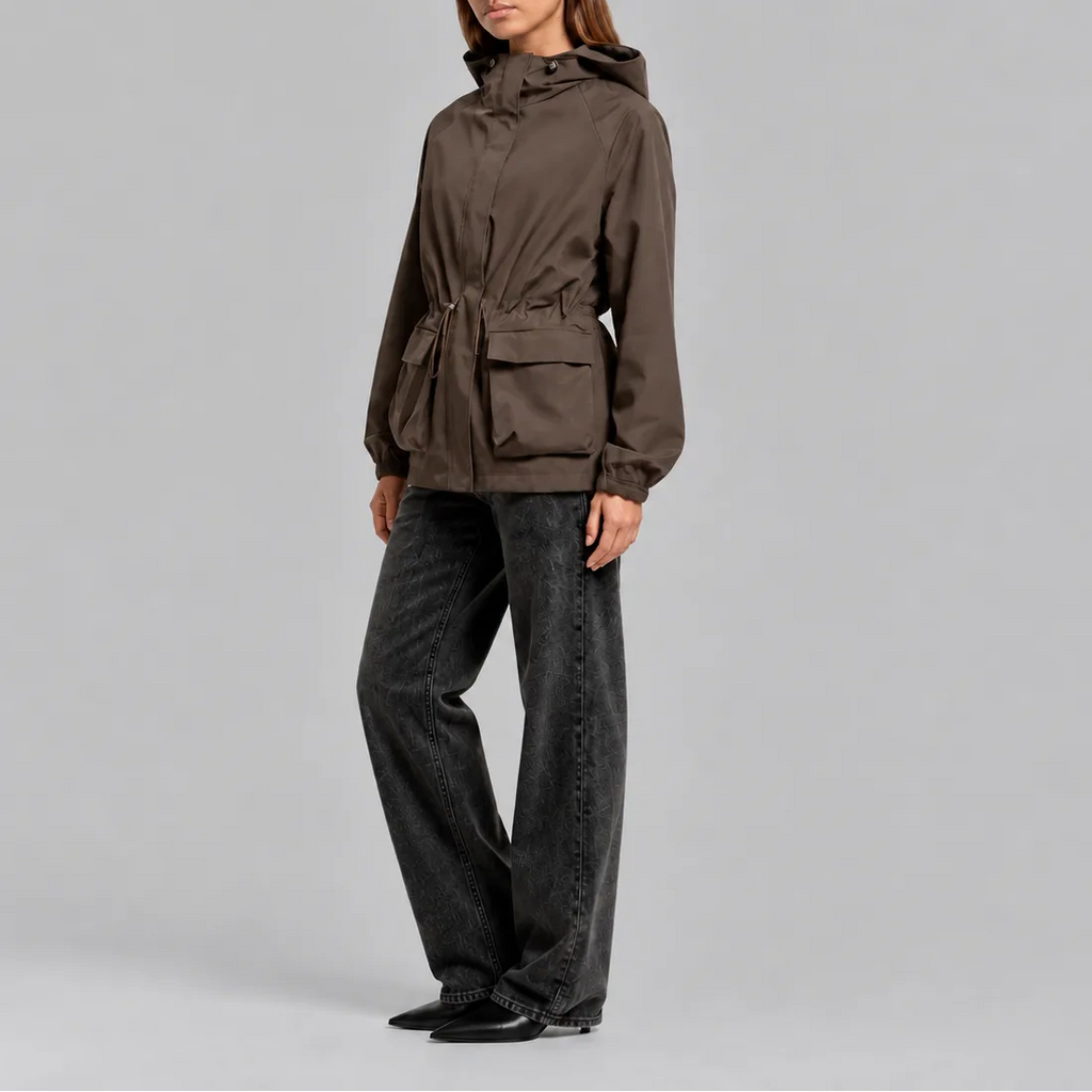 Side view of the brown jacket styled with dark jeans, showing the hood and cinched waist detail