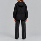 Back view of the black hooded jacket showing the drawstring waist and elasticated cuffs