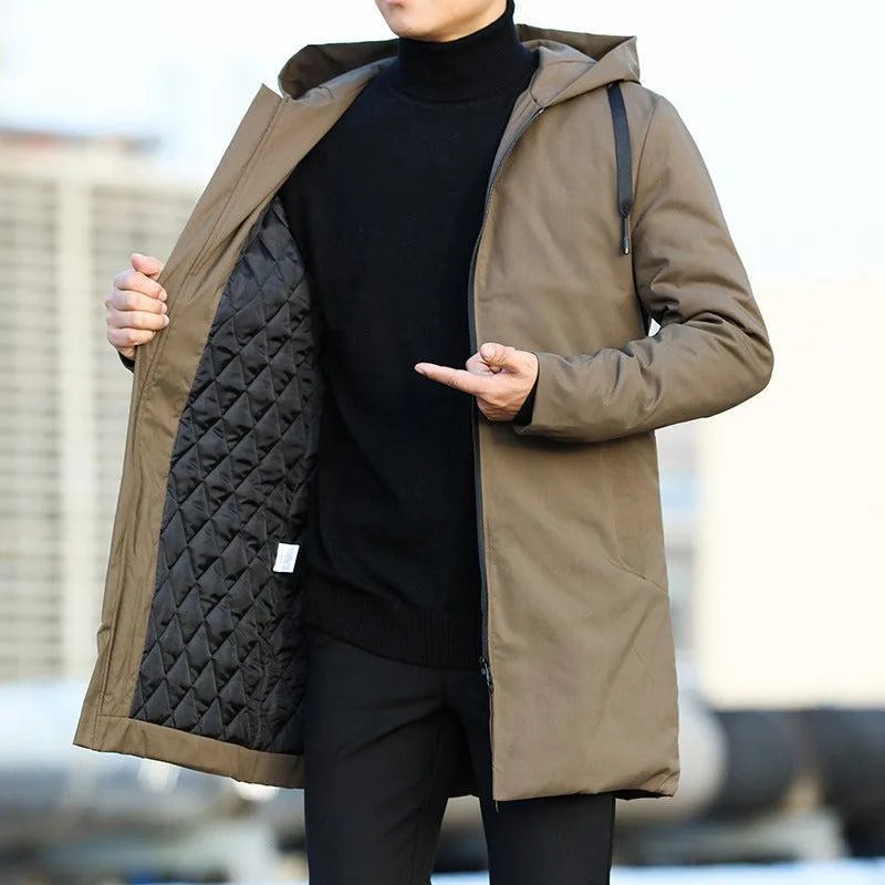 Front view of the khaki brown longline hooded parka with zip pocket detail, worn open over a black jumper.