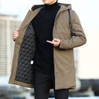 Front view of the khaki brown longline hooded parka with zip pocket detail, worn open over a black jumper.