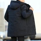 Rear view of a black hooded parka showing the long silhouette, back seam and zip pocket on the reverse side.