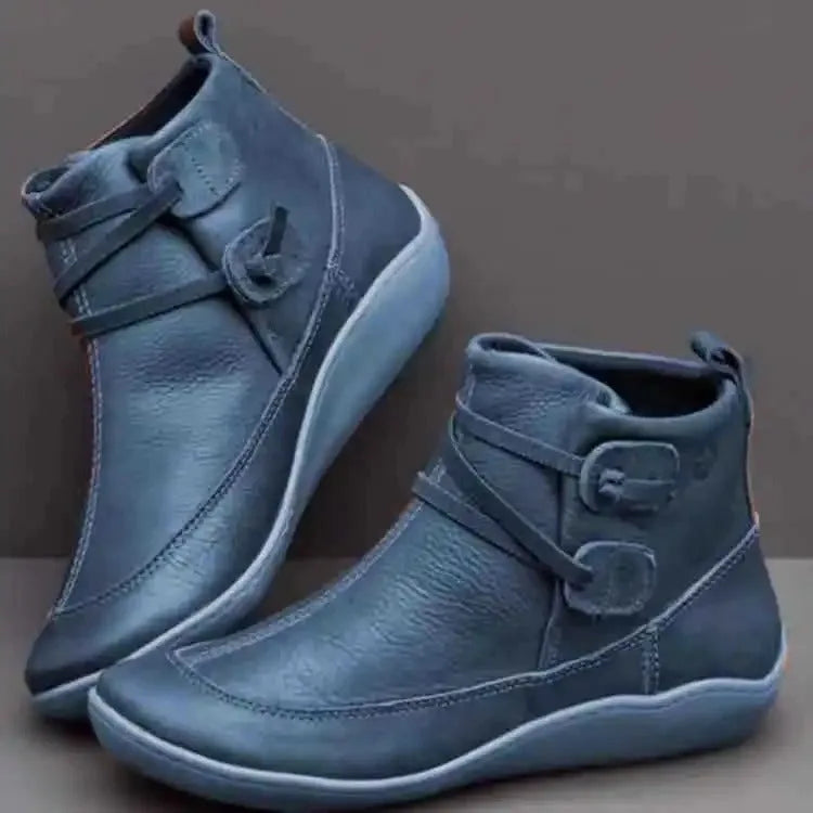 Blue leather ankle boots with pull-on tab at the heel, decorative strap detail and matching sole unit