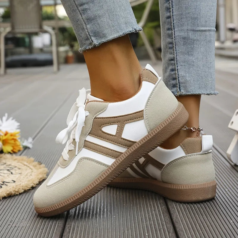 Inner side profile showing the gum sole and tan stripe detailing on a pair of lace-up trainers
