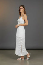 Side profile of the white lace maxi dress showing the sheer waist trim and flowing skirt with side split
