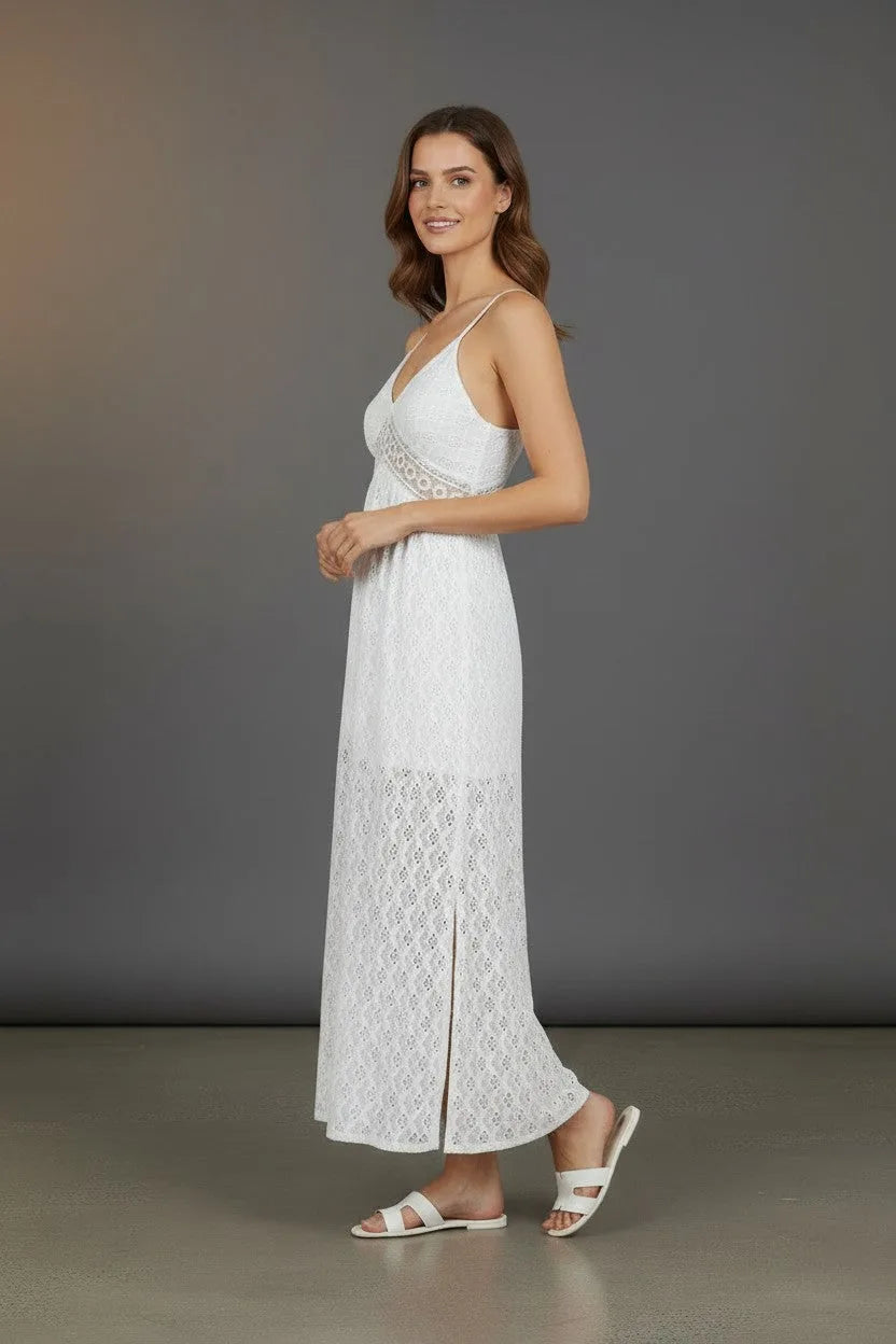 Side profile of the white lace maxi dress showing the sheer waist trim and flowing skirt with side split