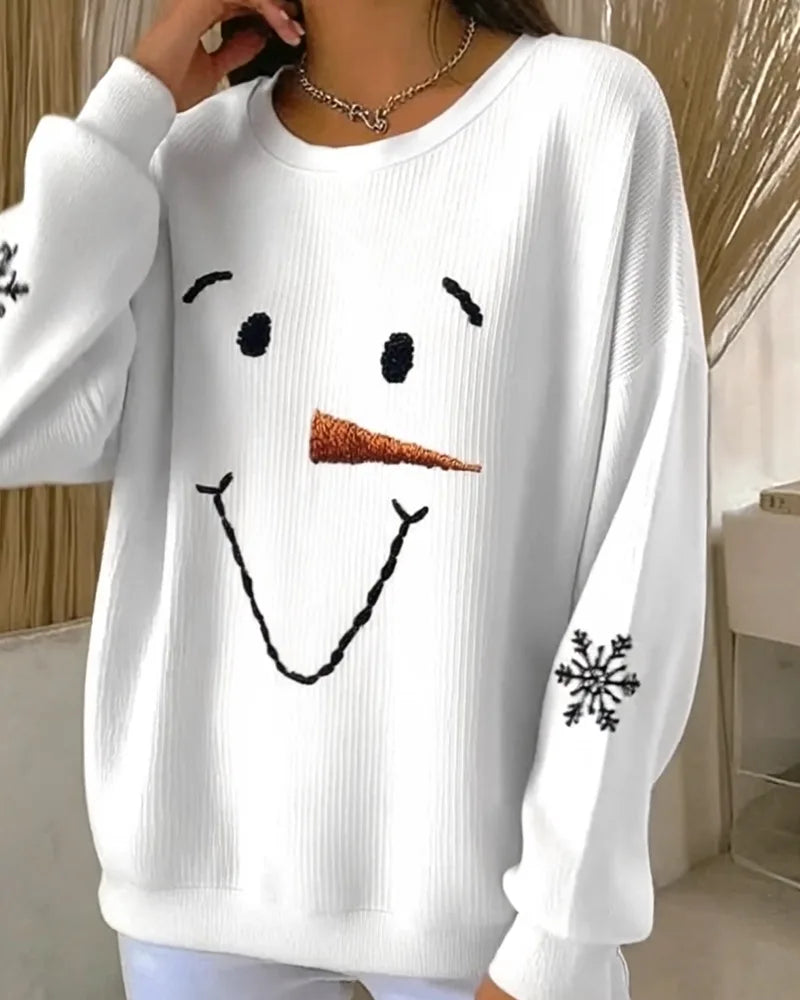 Model wearing the white snowman jumper with one hand raised, showing the relaxed oversized sleeve and hem