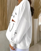 Side profile of the white sweatshirt showing the ribbed knit texture and a small snowflake embroidery on the sleeve