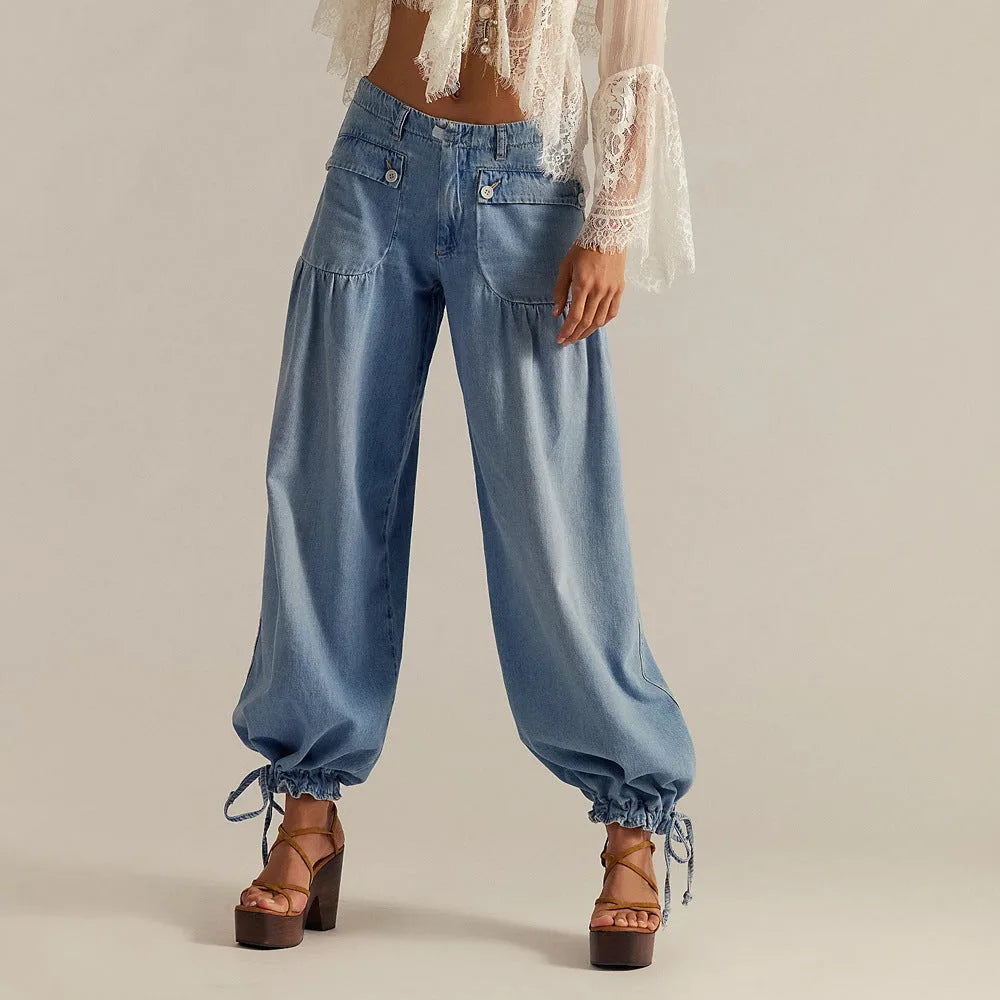 Front view of light blue chambray wide-leg jeans with paperbag-style gathered hip pockets, worn with lace top and platform sandals