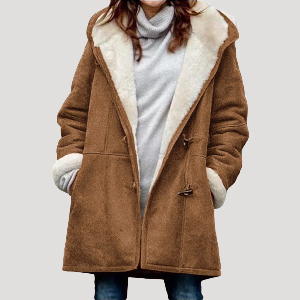 Camel brown duffle coat with cream borg lining and wooden toggle fastenings, hands tucked into the pockets
