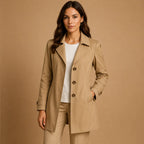 Khaki tailored trenchcoat with tortoiseshell buttons and fitted waist, styled over a white top and matching trousers