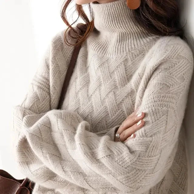 Close-up of a light beige polo neck jumper with woven knit detail, worn with a brown leather bag
