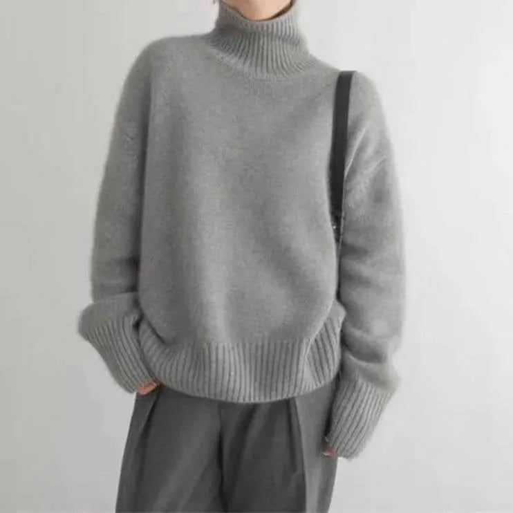 Close up of cream ribbed cuff and forearm detail showing chunky knit texture