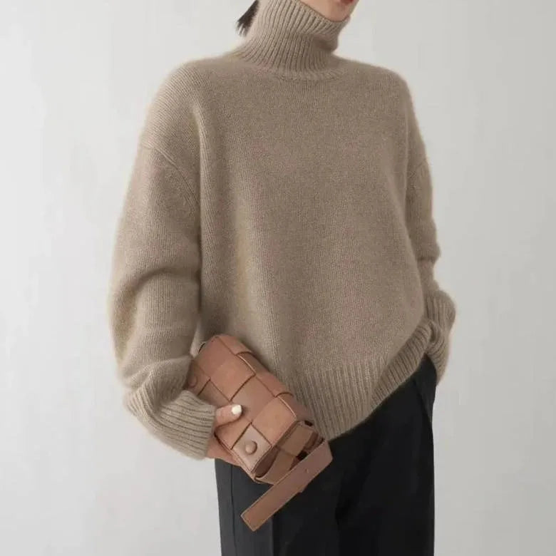 Beige polo neck jumper paired with a woven leather crossbody bag, showing relaxed drop-shoulder fit