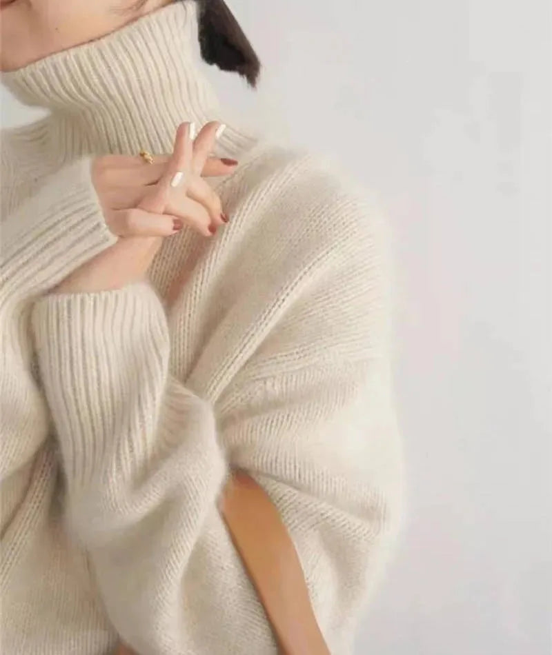 Close up side profile of ribbed sleeve detail on a cream oversized polo neck jumper