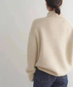 Back view of a cream polo neck jumper showing raglan seam construction and ribbed collar