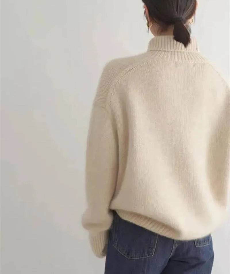 Back view of a cream polo neck jumper showing raglan seam construction and ribbed collar