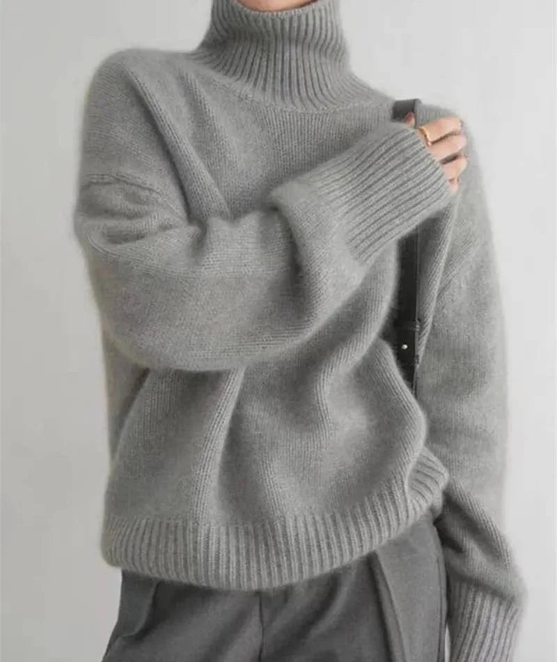 Front close up of cream ribbed polo neck collar with model's hand adjusting the neckline