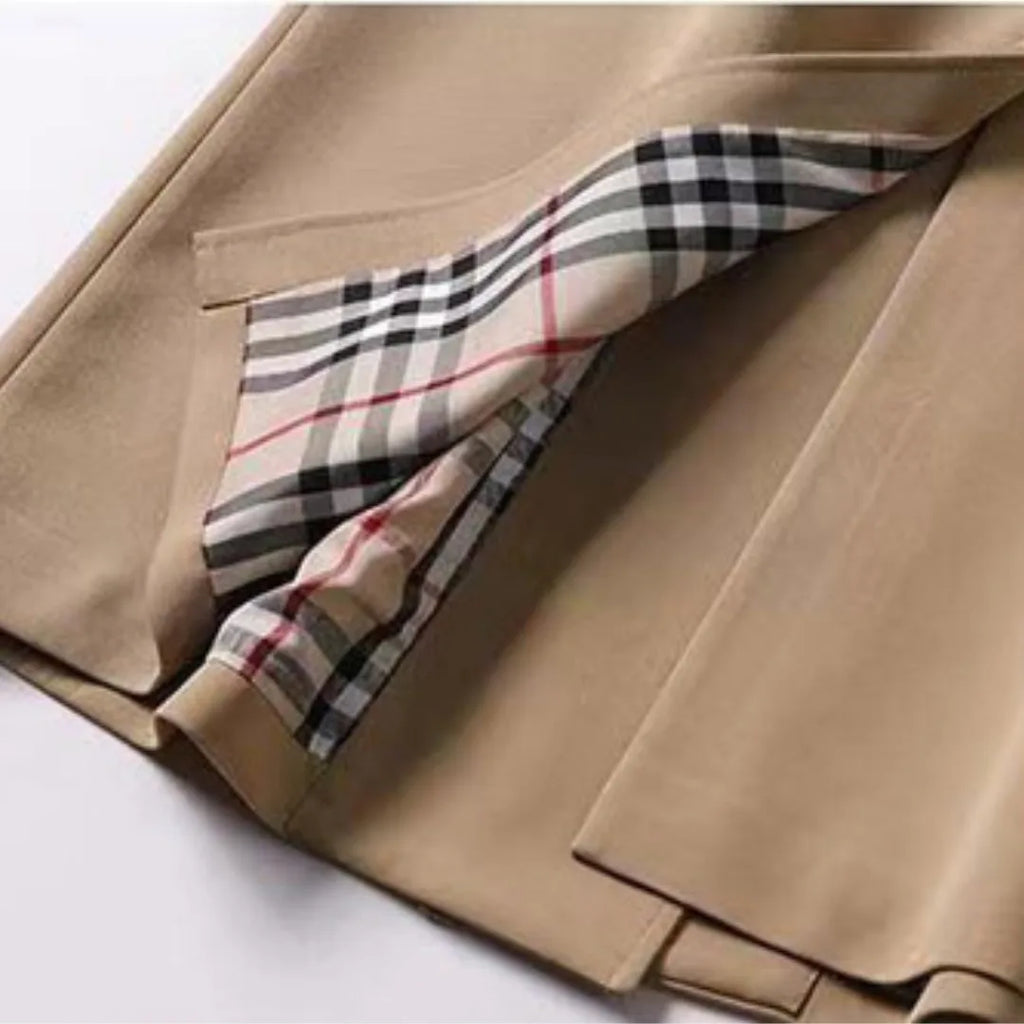Camel trench coat hem detail revealing the checked interior lining and side vent