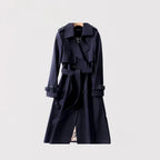 Navy trench coat with structured lapels and tie belt, front view against a plain backdrop