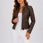 Close-up of a dark brown faux leather biker jacket, unzipped over a white top, showing collar snap buttons