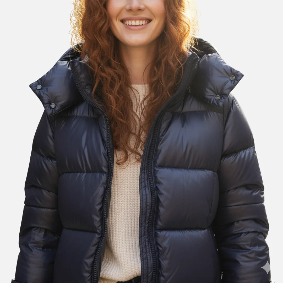 Close-up of the navy puffer jacket showing the quilted baffles, zip placket and hood snap buttons