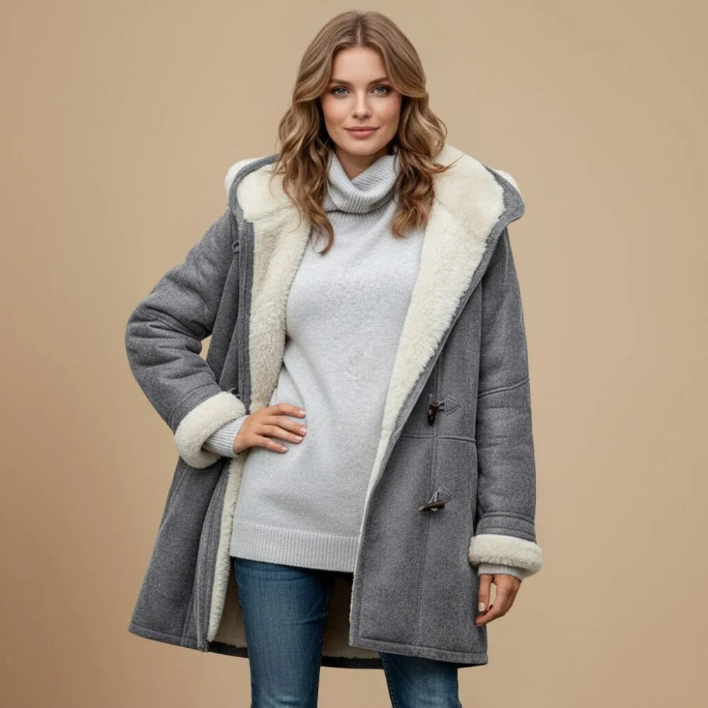 Three-quarter view of the grey duffle coat showing the cream fleece collar and cuffs with raw denim jeans