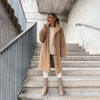 Model in a camel teddy coat with wide lapel collar, worn open over a matching loungewear set