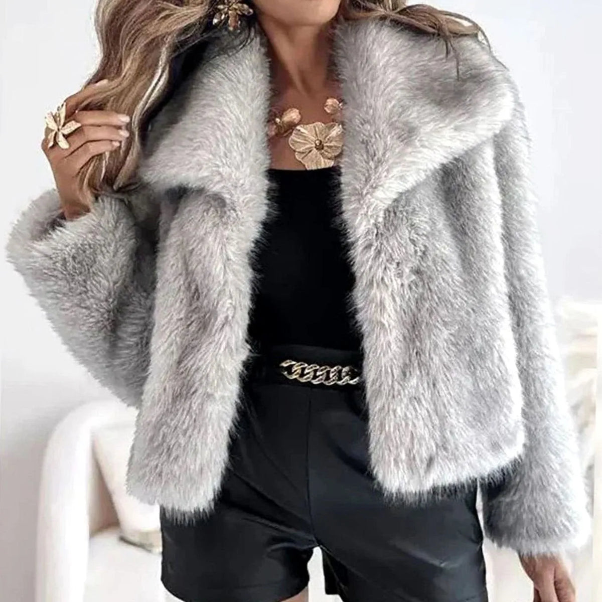 Light grey faux fur cropped jacket with oversized collar, worn open over black satin shorts