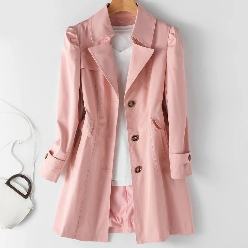 Pink tailored trench coat with notch lapel and shoulder detailing, shown open over a white top on a hanger