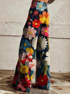 Side profile of flared floral denim trousers showing the wide hem and back pocket detail with oversized painted flowers