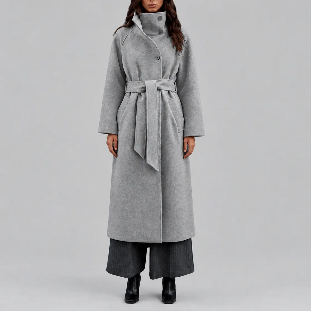 Front view of a woman wearing a grey wool-style wrap coat with wide stand collar and tie belt