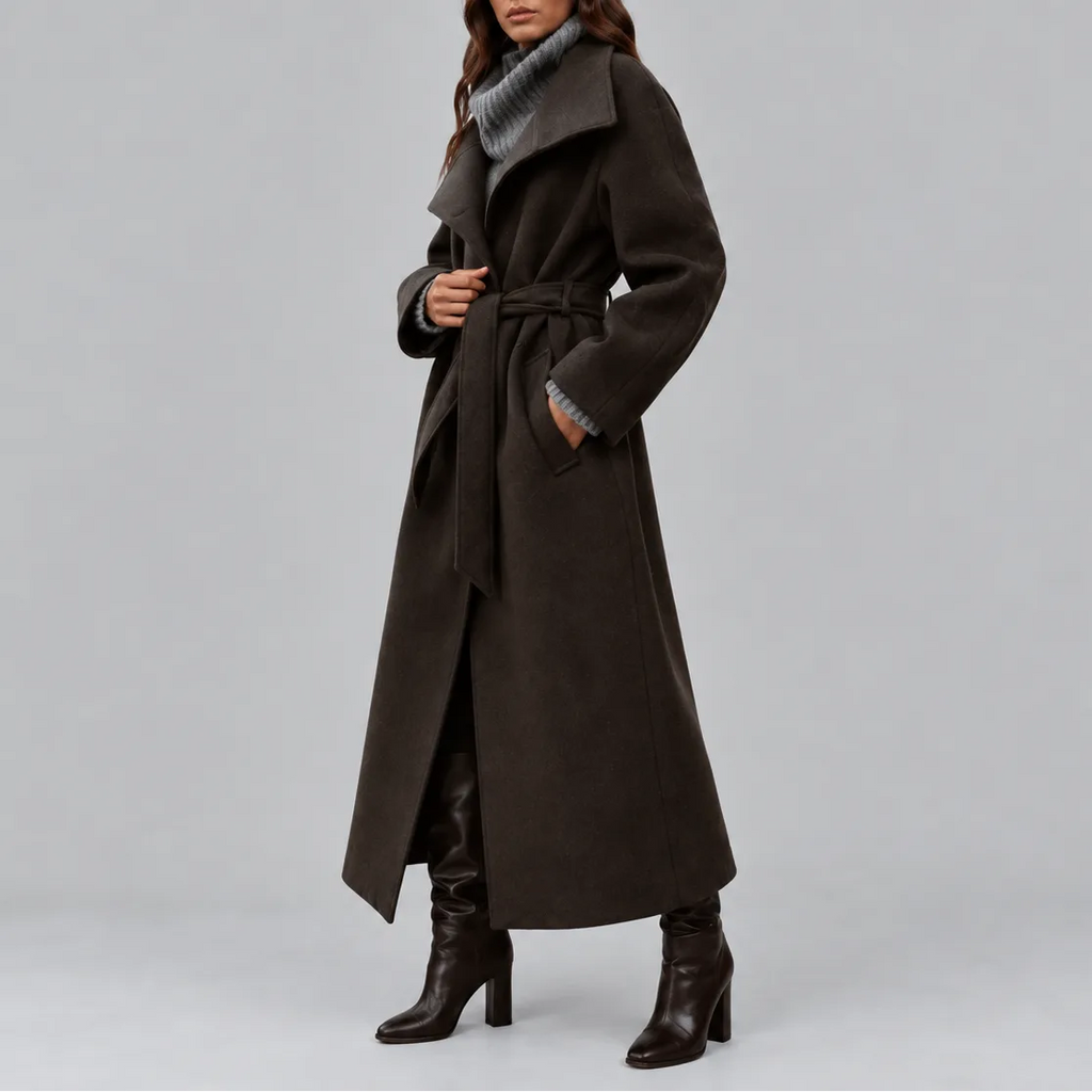 Side profile of the dark brown longline wool coat showing the wrap front and tall boots